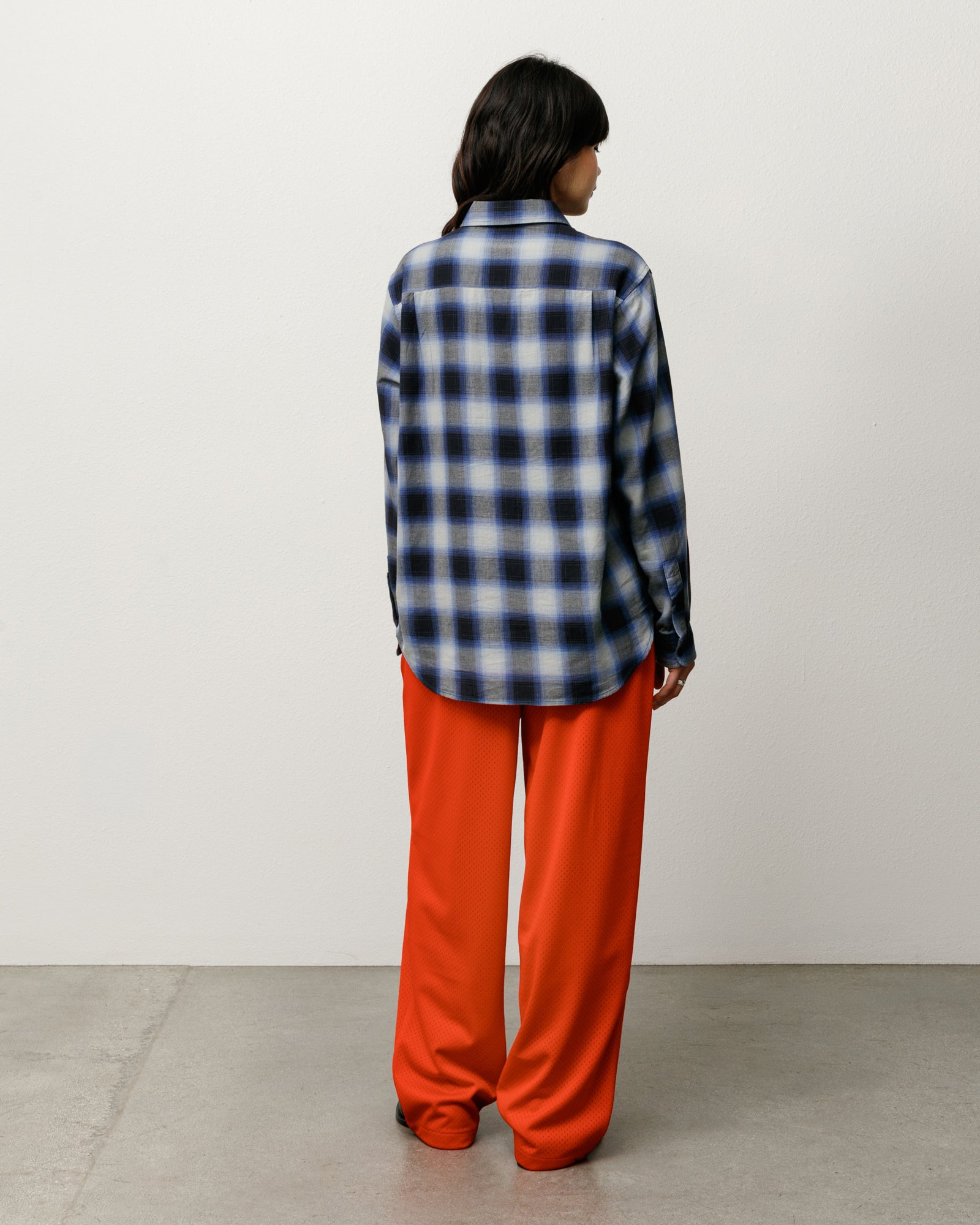 Unisex long-sleeve ombre plaid shirt in black/blue, back view on model.