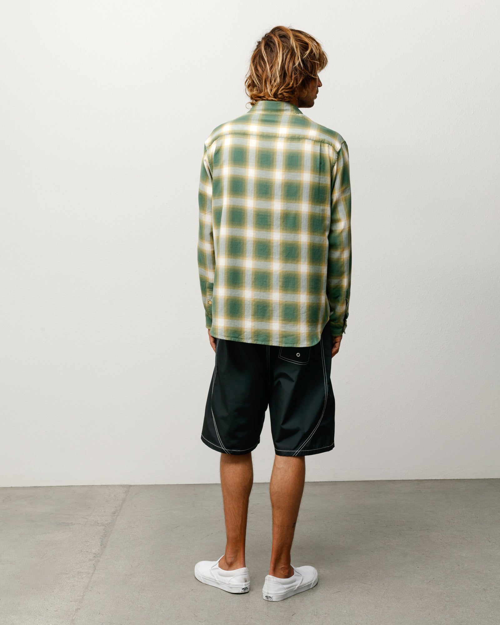 Back view of a green ombre plaid long-sleeve button-up shirt styled on a model.