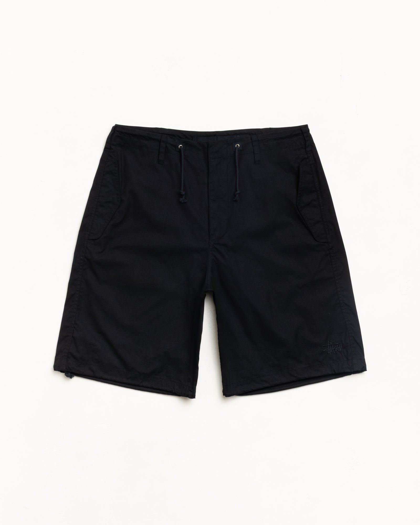 Black unisex baggy shorts with drawcord waist, side pockets and subtle logo at hem