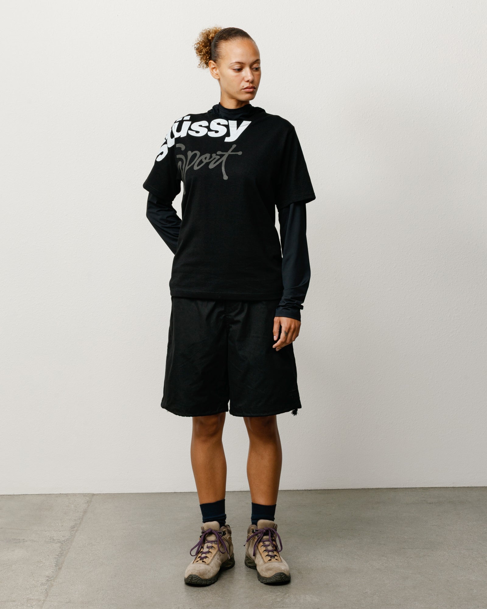 Black baggy cotton-nylon shorts on model with drawcord waist and relaxed fit.