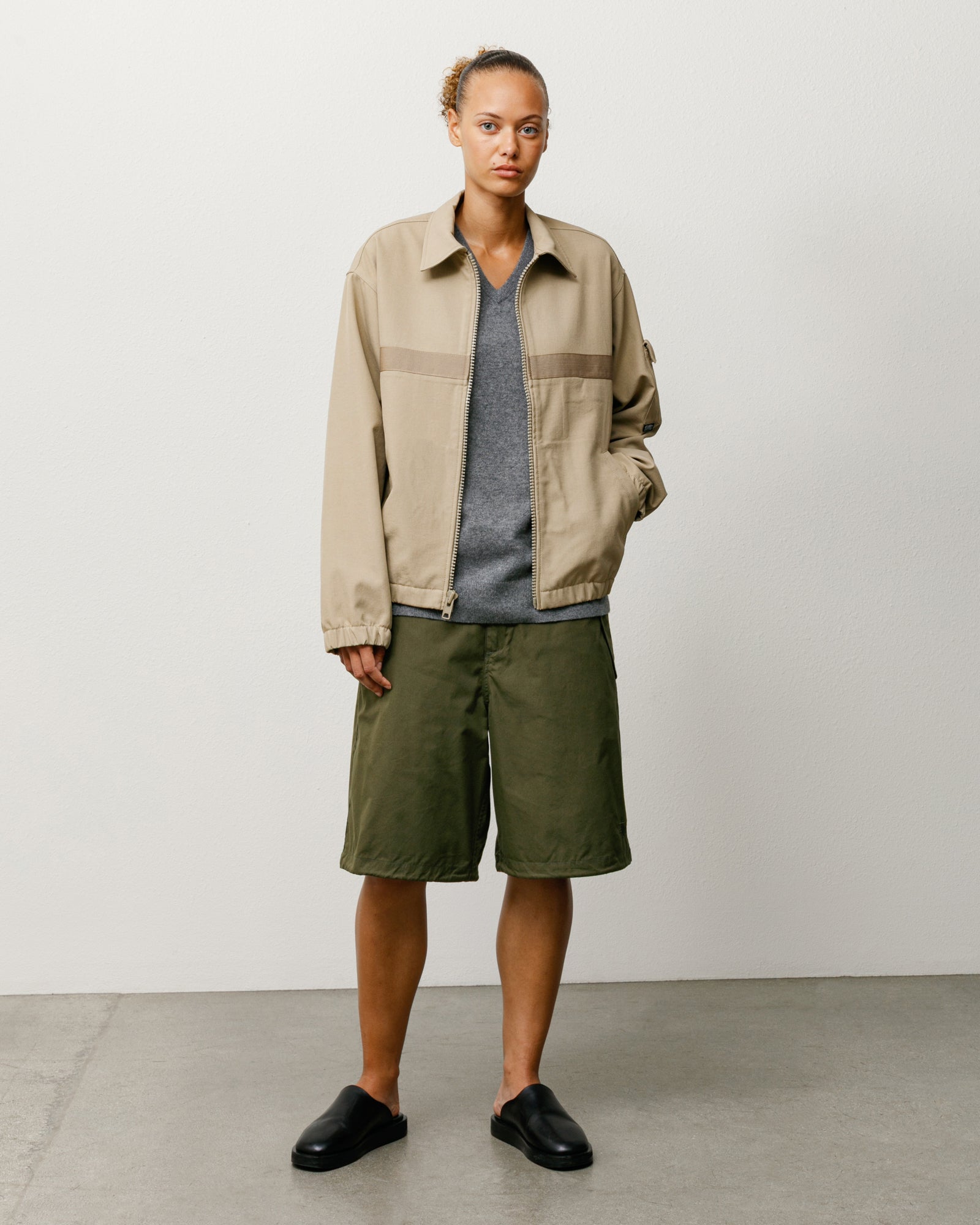 Olive unisex regular-fit surplus shorts worn on model; knee-length, casual styling.