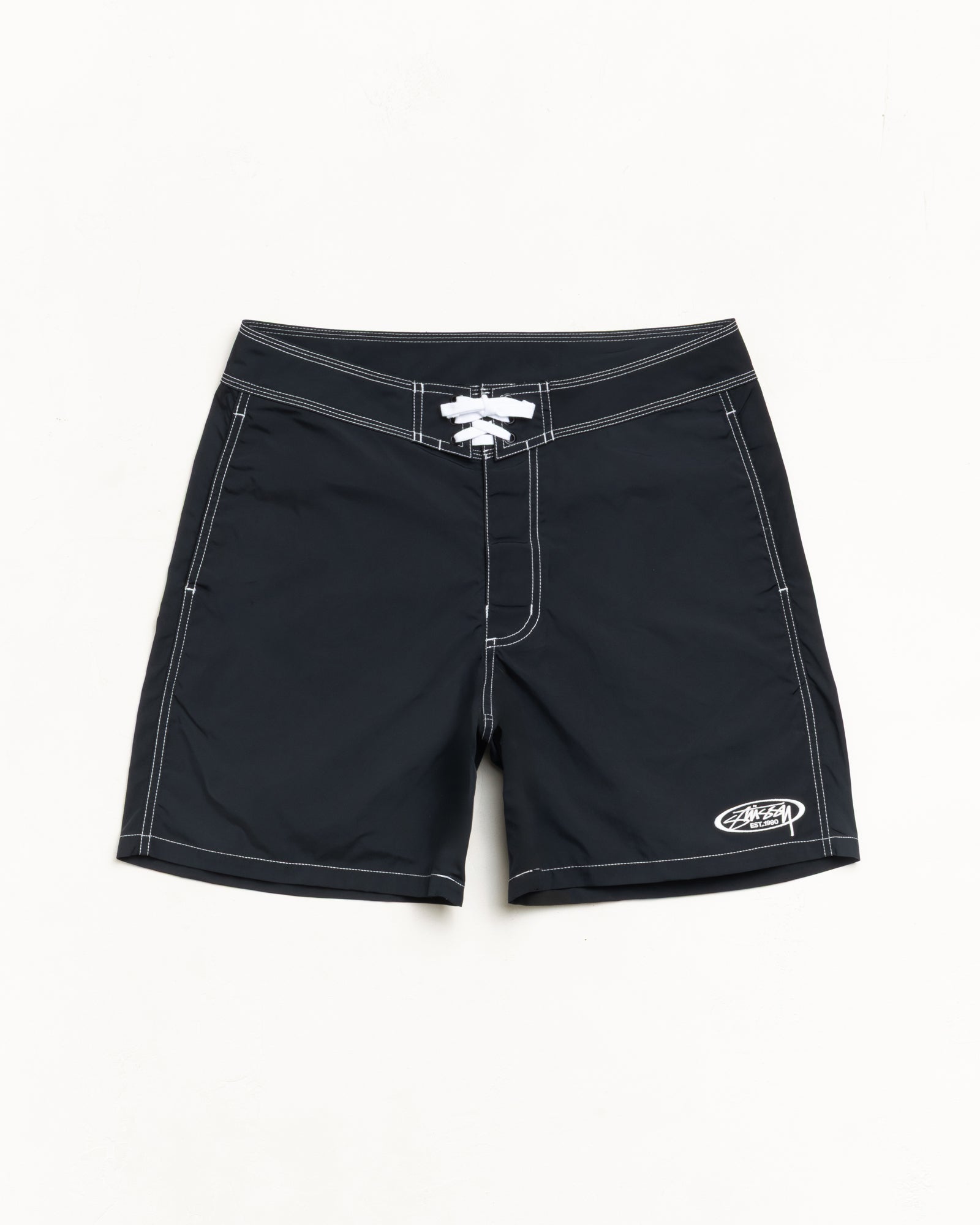 Black unisex board shorts with contrast stitching, lace-up waist, and logo at hem