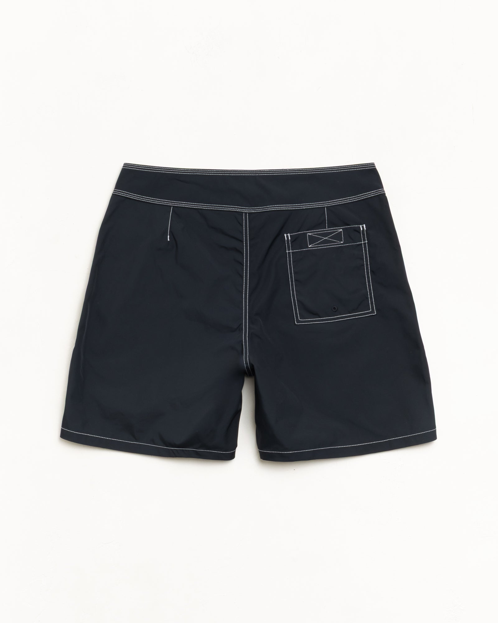 Black Coastal board short, back flat lay showing contrast stitching and rear patch pocket.