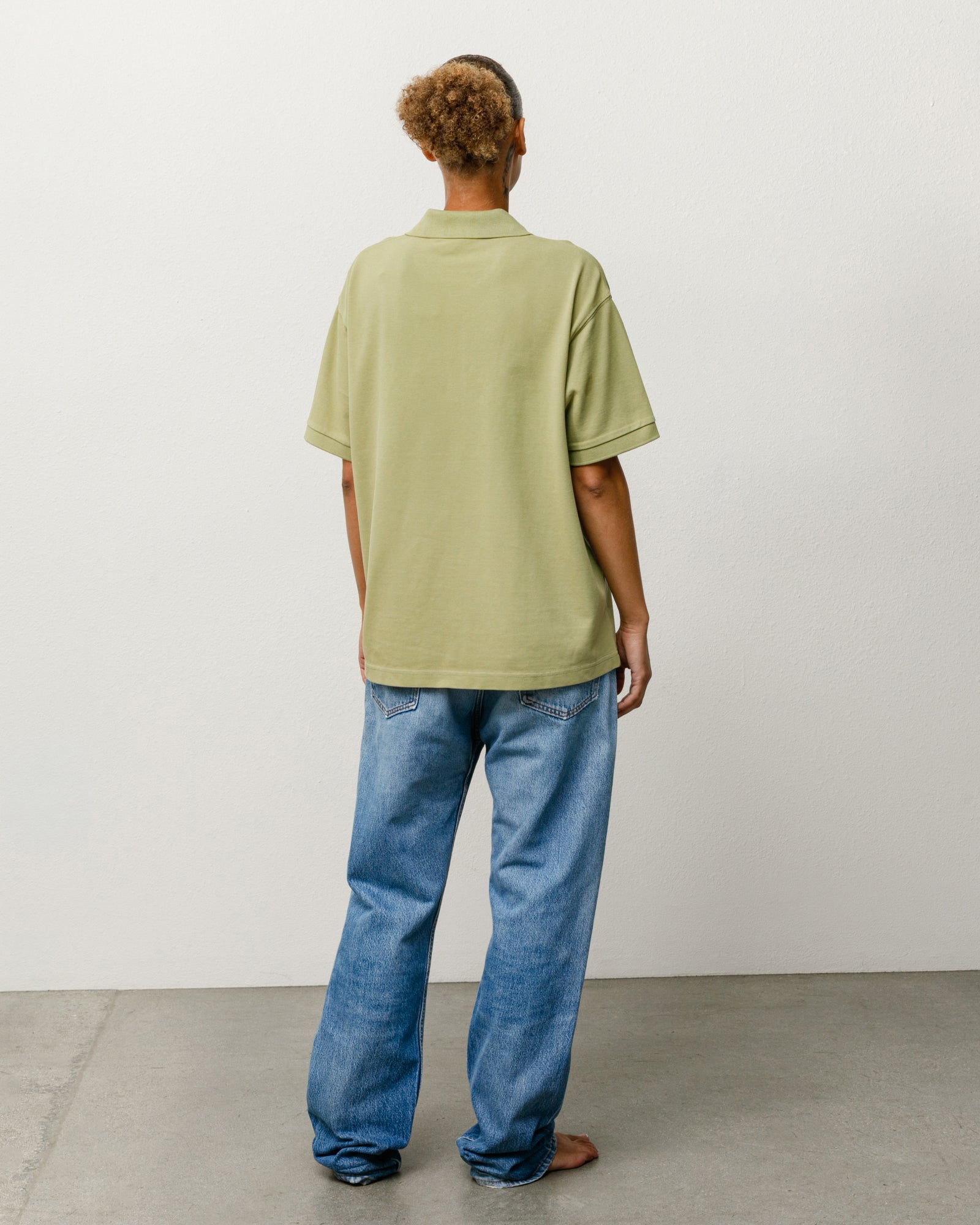 Leaf green pique cotton unisex polo, short-sleeve, back view on model