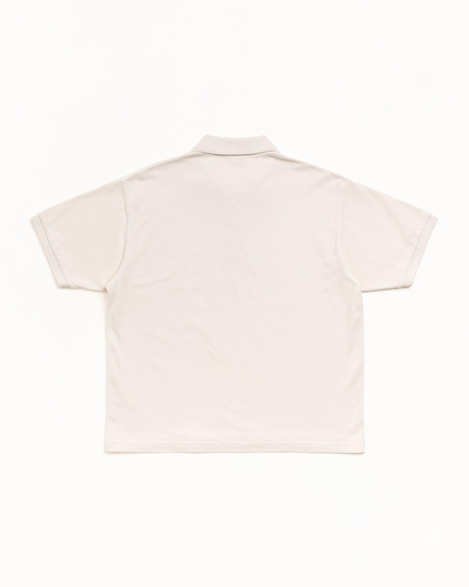 Off white classic pique polo, back flat lay; short sleeves with rib collar and cuffs.