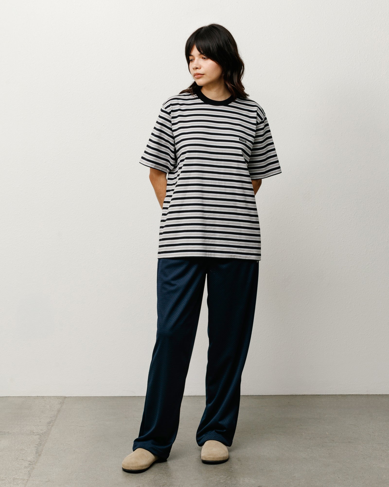 Black and grey striped cotton tee with ribbed crewneck, relaxed fit on model