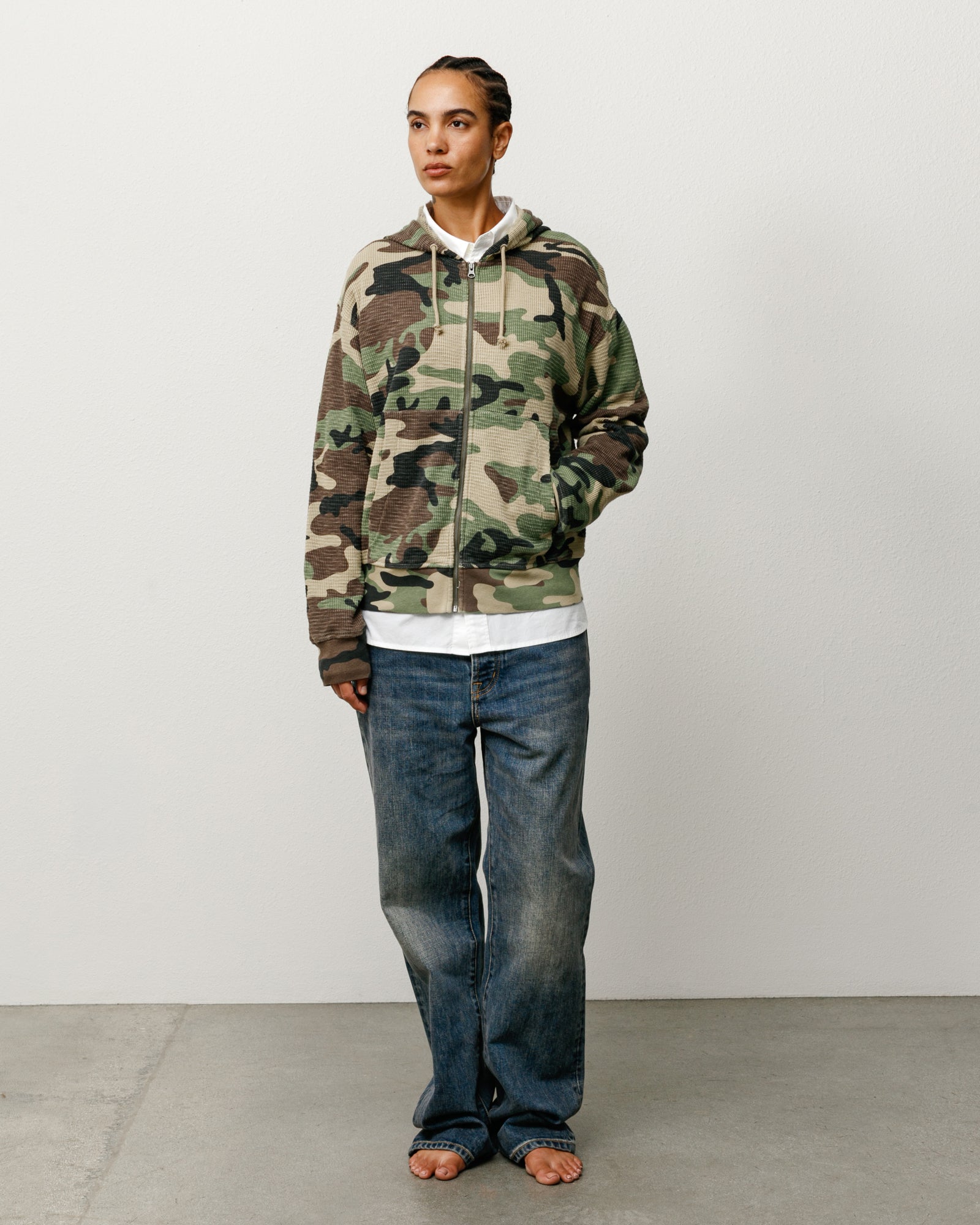 Camo thermal full-zip hoodie with drawcord hood and ribbed cuffs, shown on model.