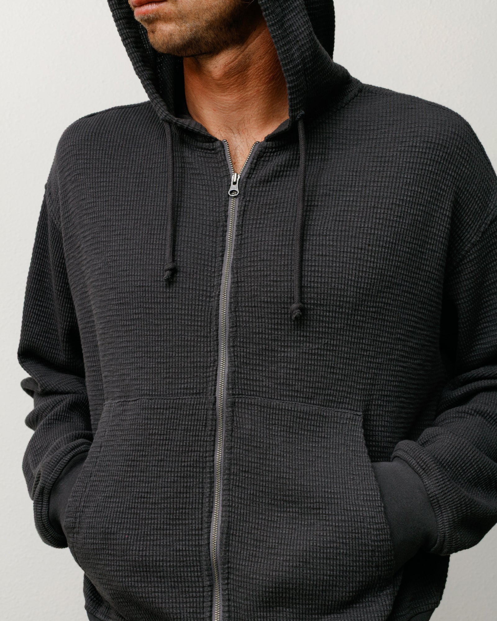Faded black thermal zip hoodie with waffle-knit texture, drawcord hood and kangaroo pocket