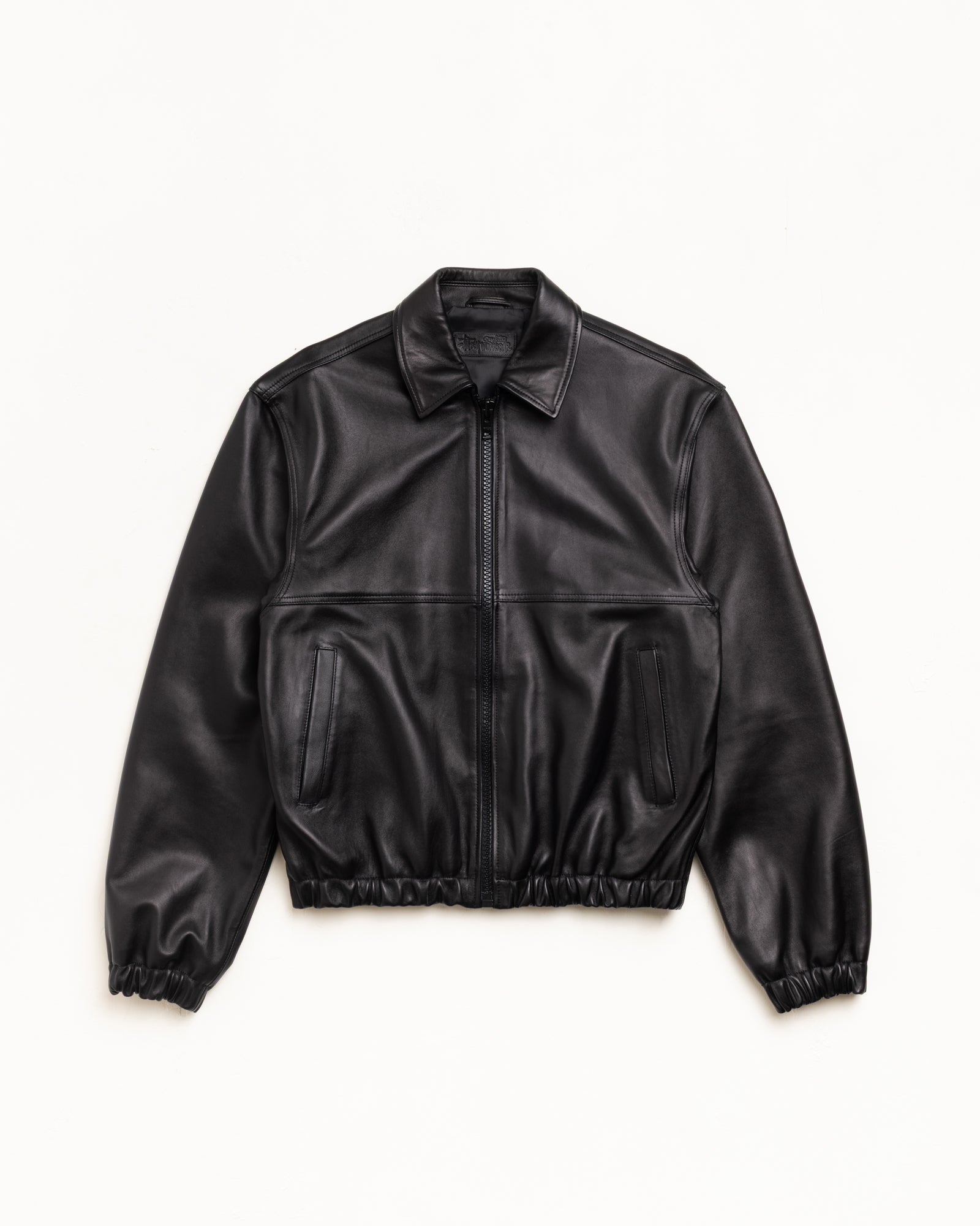 Black leather zip-front work jacket with welt pockets and elastic hem, unisex long sleeve