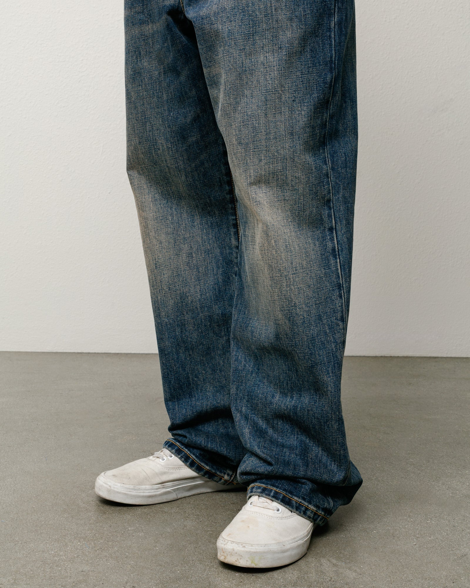 Blue slub denim jeans with relaxed, baggy fit shown on model legs