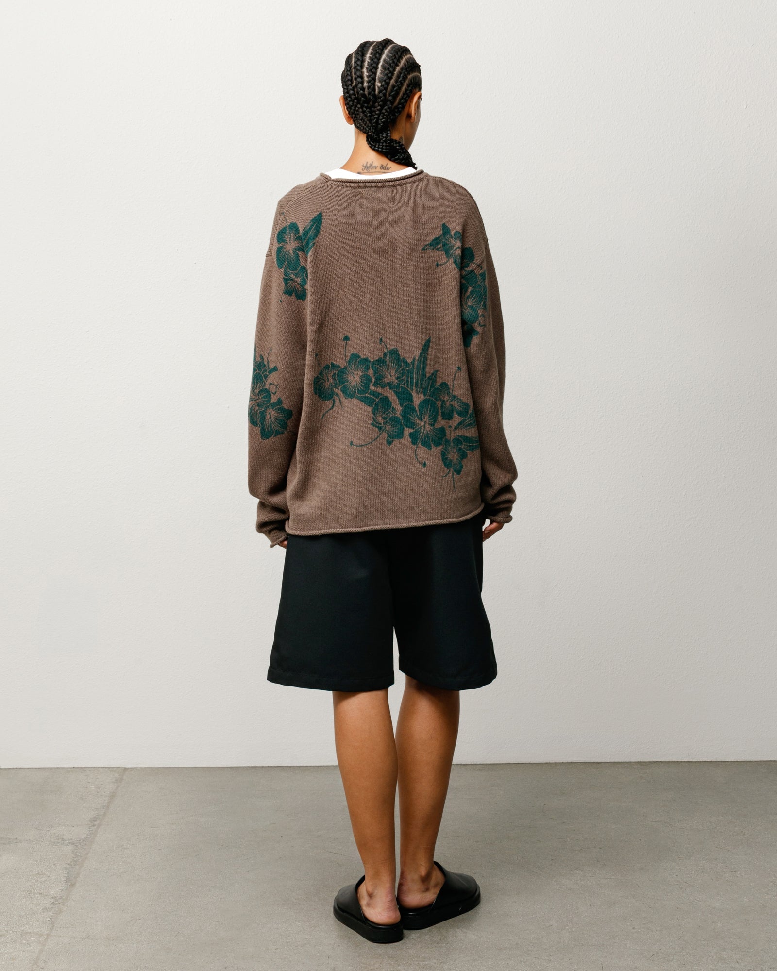 Brown roll-neck sweater with green floral motif, back view on model