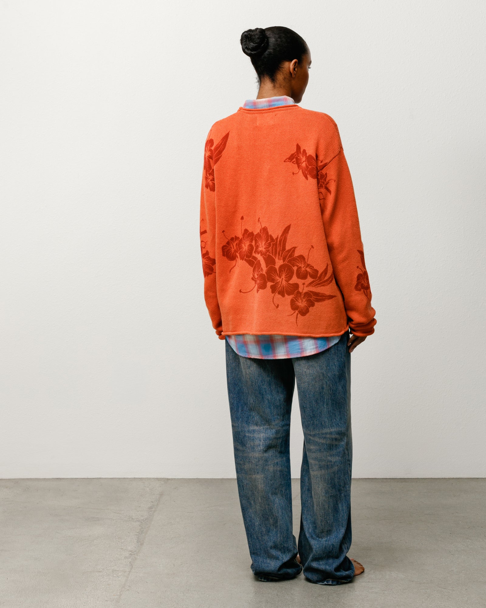 Rust floral roll neck sweater with floral knit, shown on model from the back.