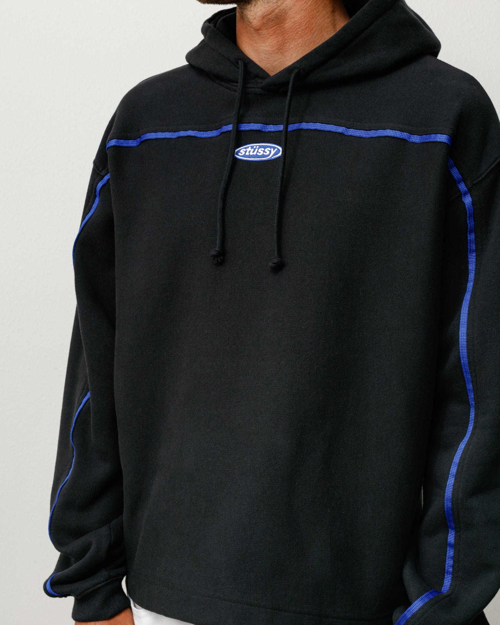 Black unisex pullover hoodie with blue contrast piping and a small chest logo