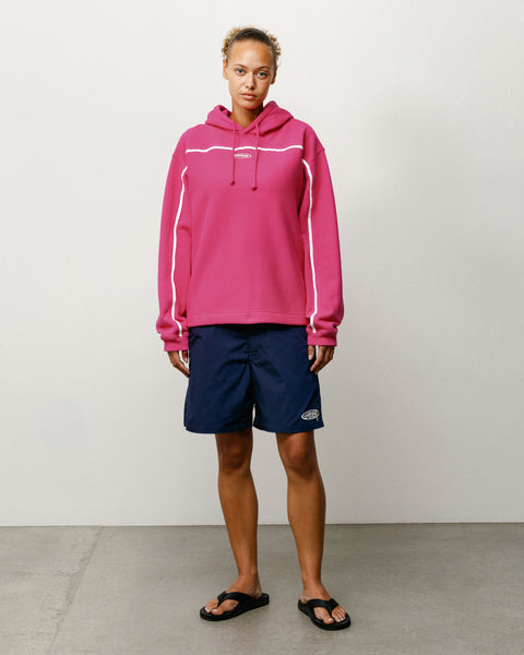 Pink unisex pullover hoodie with white piping and drawcord hood, shown on model