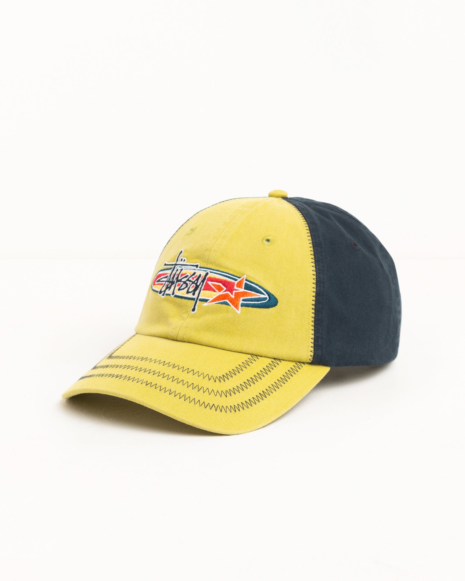 Lime cap with contrast navy panels, zig-zag brim stitching, Stüssy logo embroidery