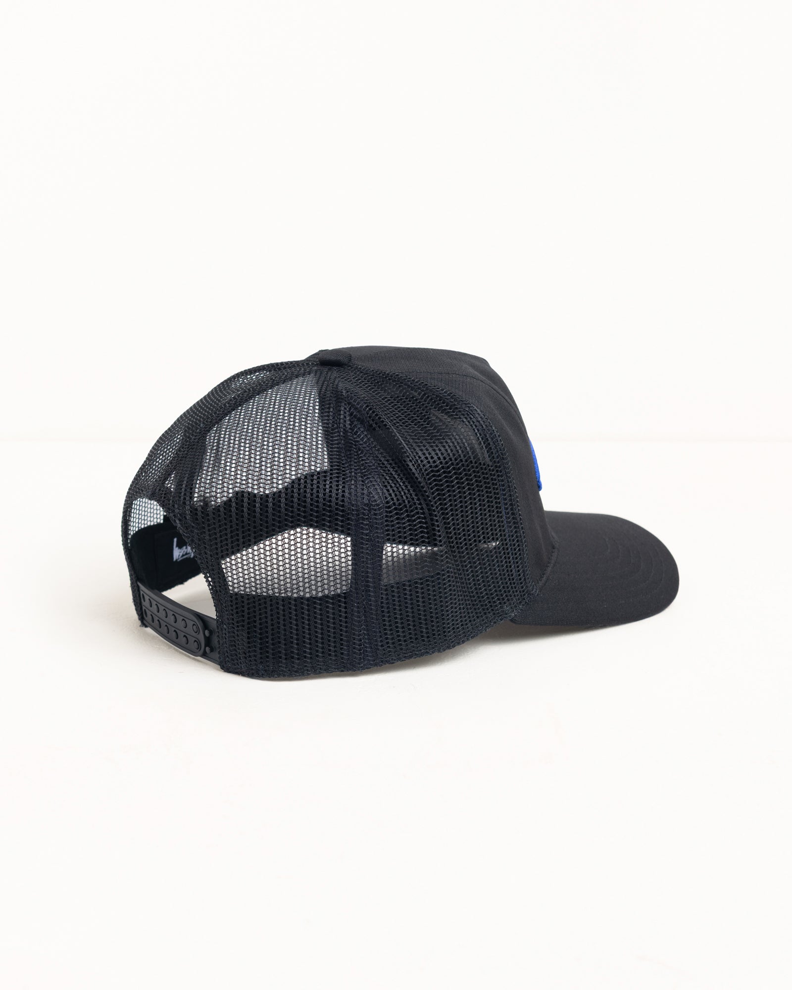 Black mesh-back unisex trucker cap with snapback closure, side view