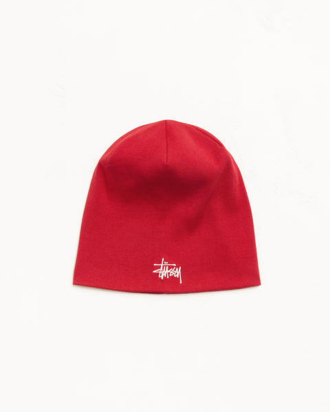 Red cotton jersey skullcap beanie with white embroidered logo, unisex fit.