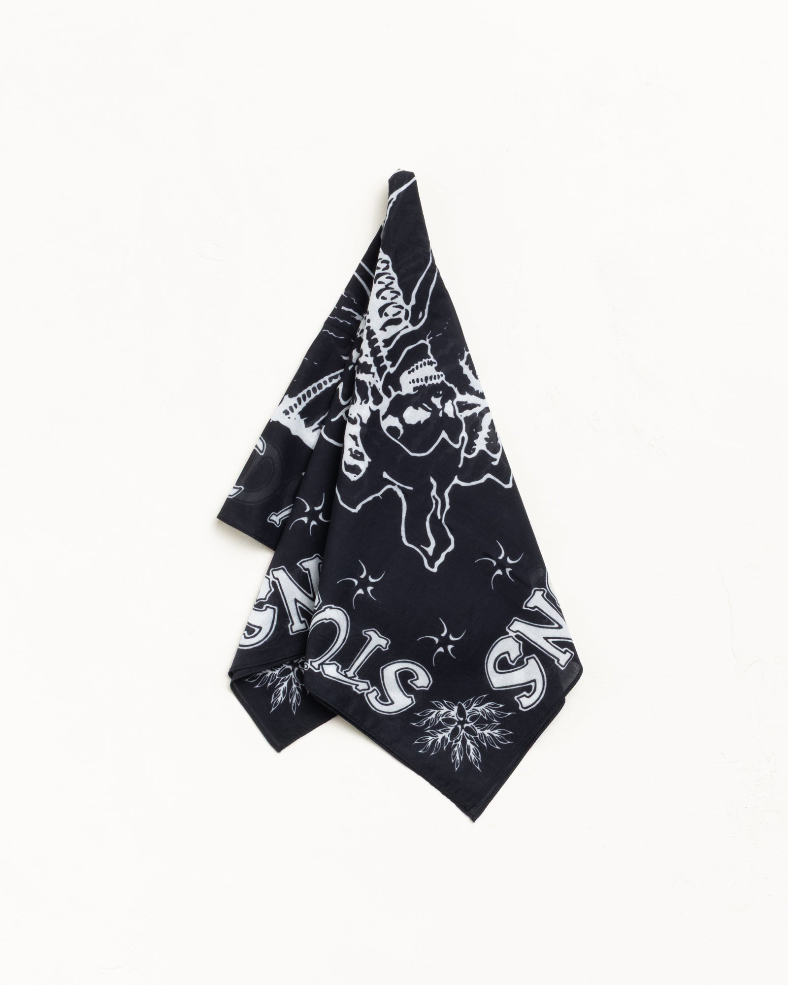 Black cotton bandana with white graphic print, square and draped against a white background