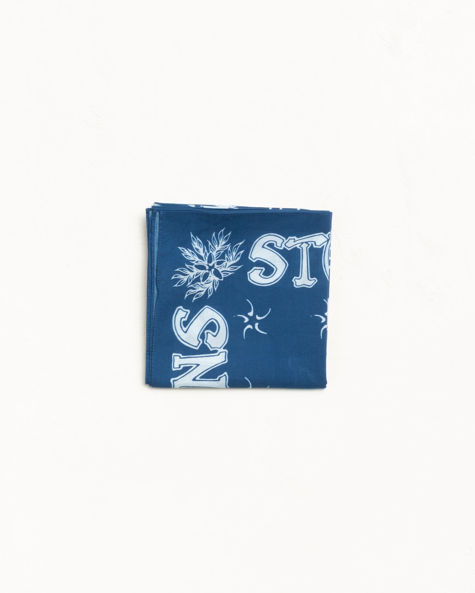 Folded blue cotton bandana with white graphic print details