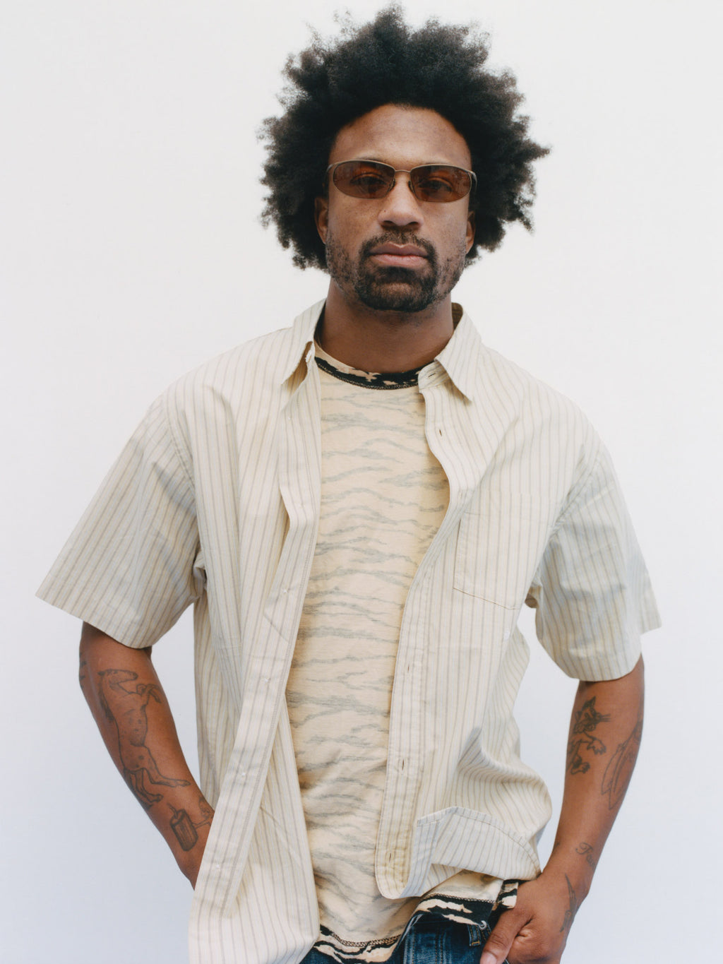 Model wearing Standard SS Shirt in Yellow Stripe over a patterned t-shirt against a white background.